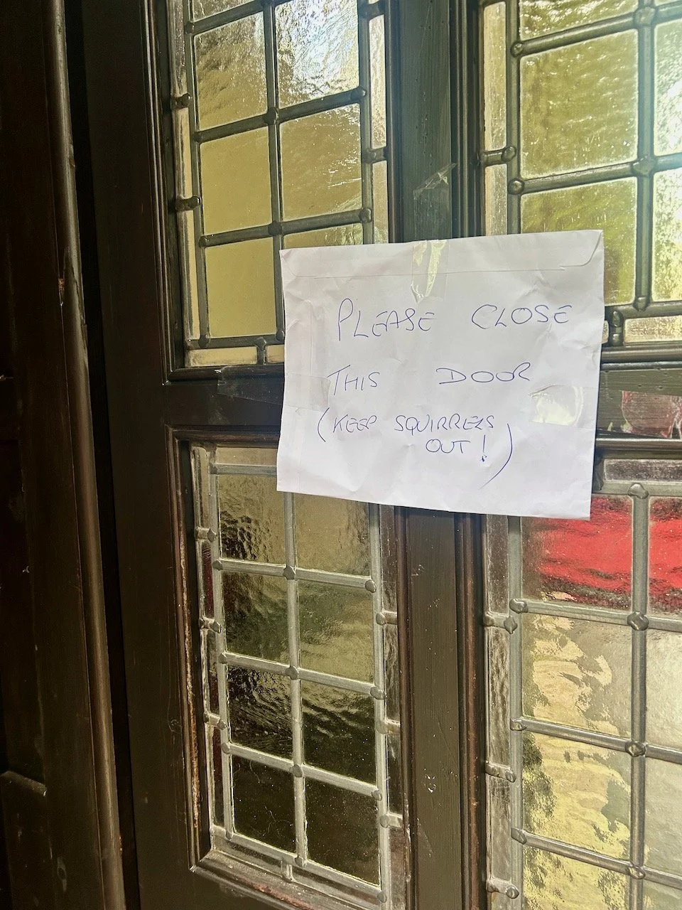 'Please close this door (keep squirrels out!) - handwritten note on the church door