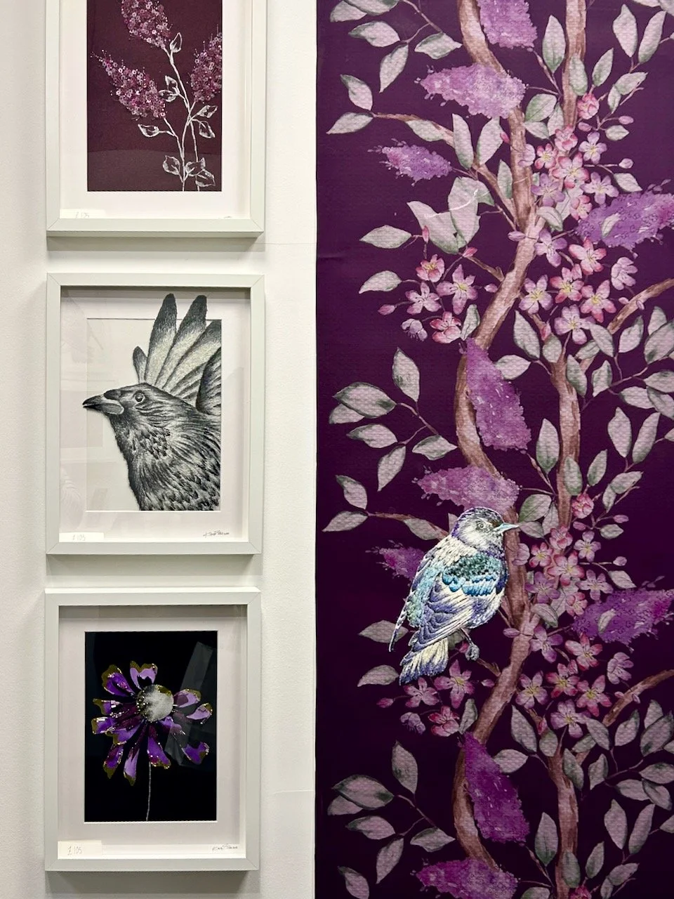On the right is a long panel in purples with an embroidered bird on the lower branches, alongside on the left are embroidered flowers and another bird in flight - both framed