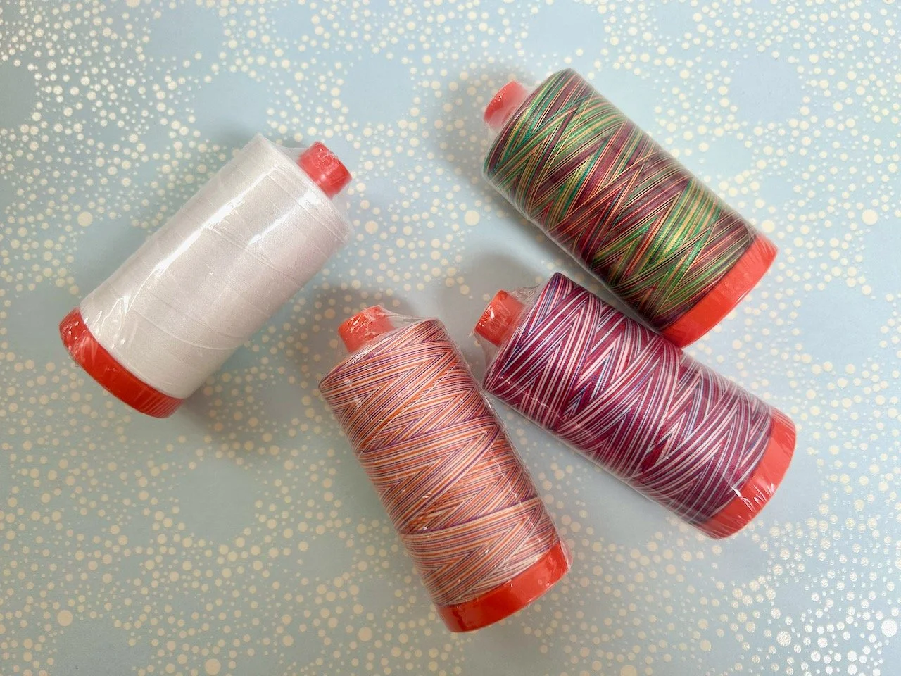 Four aurifil threads - white, desert dawn, liberty and marrakesh