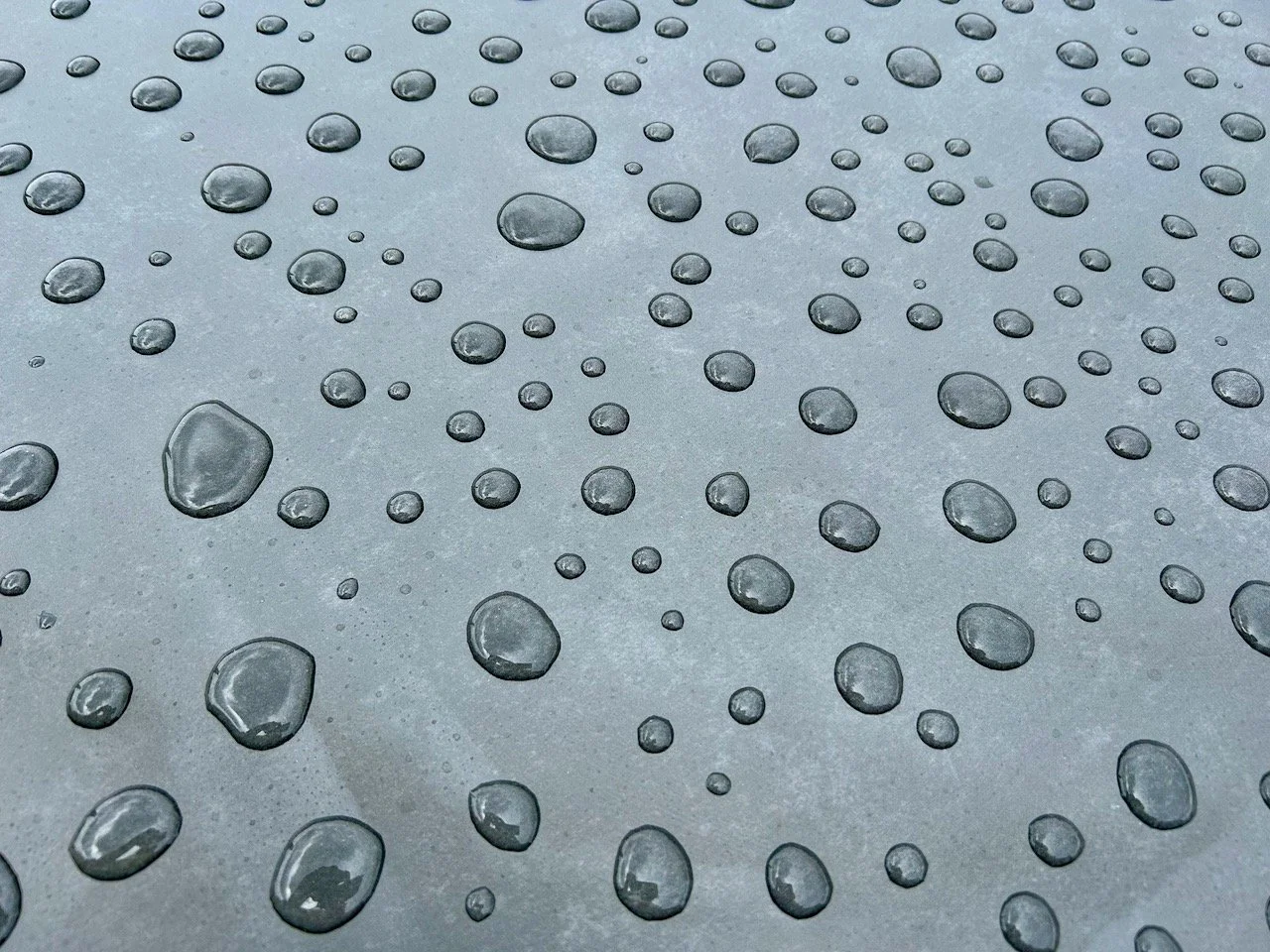 drops of water pooling on a grey surface