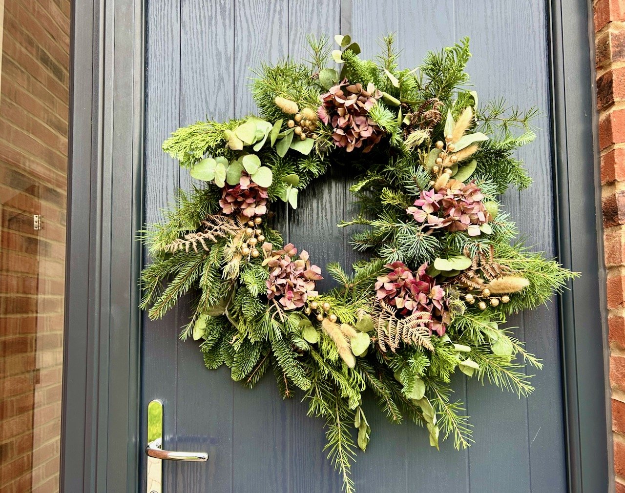 The wreath finally hung on our back (front) door, but... look above the door handle