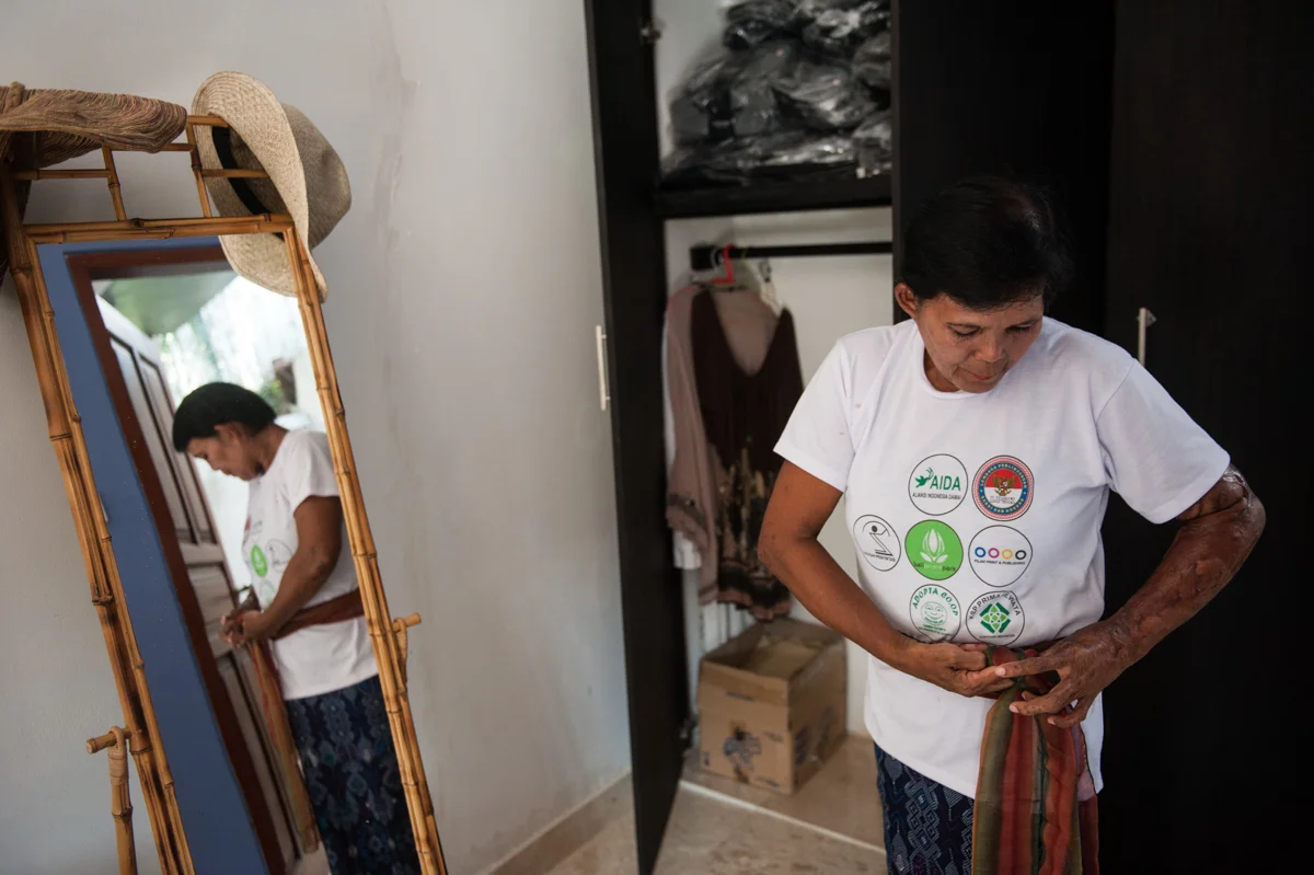 Yayuk ties a scarf to her waist in the villa belonging to a German citizen at Kerobokan, Bali on Oct. 12. She has been working there for two years.
