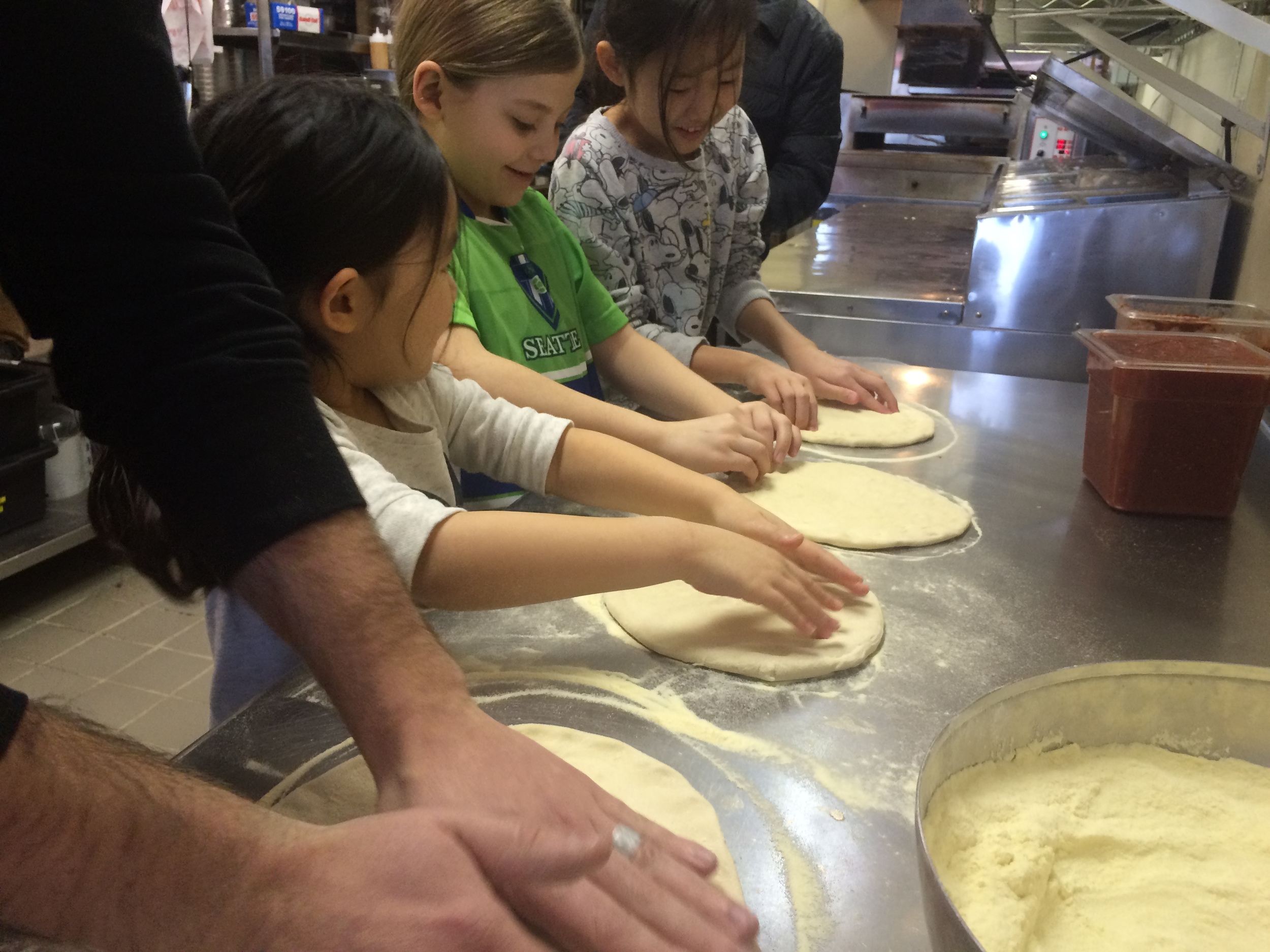 Teaching pizza making at Wooden Paddle Pizza.