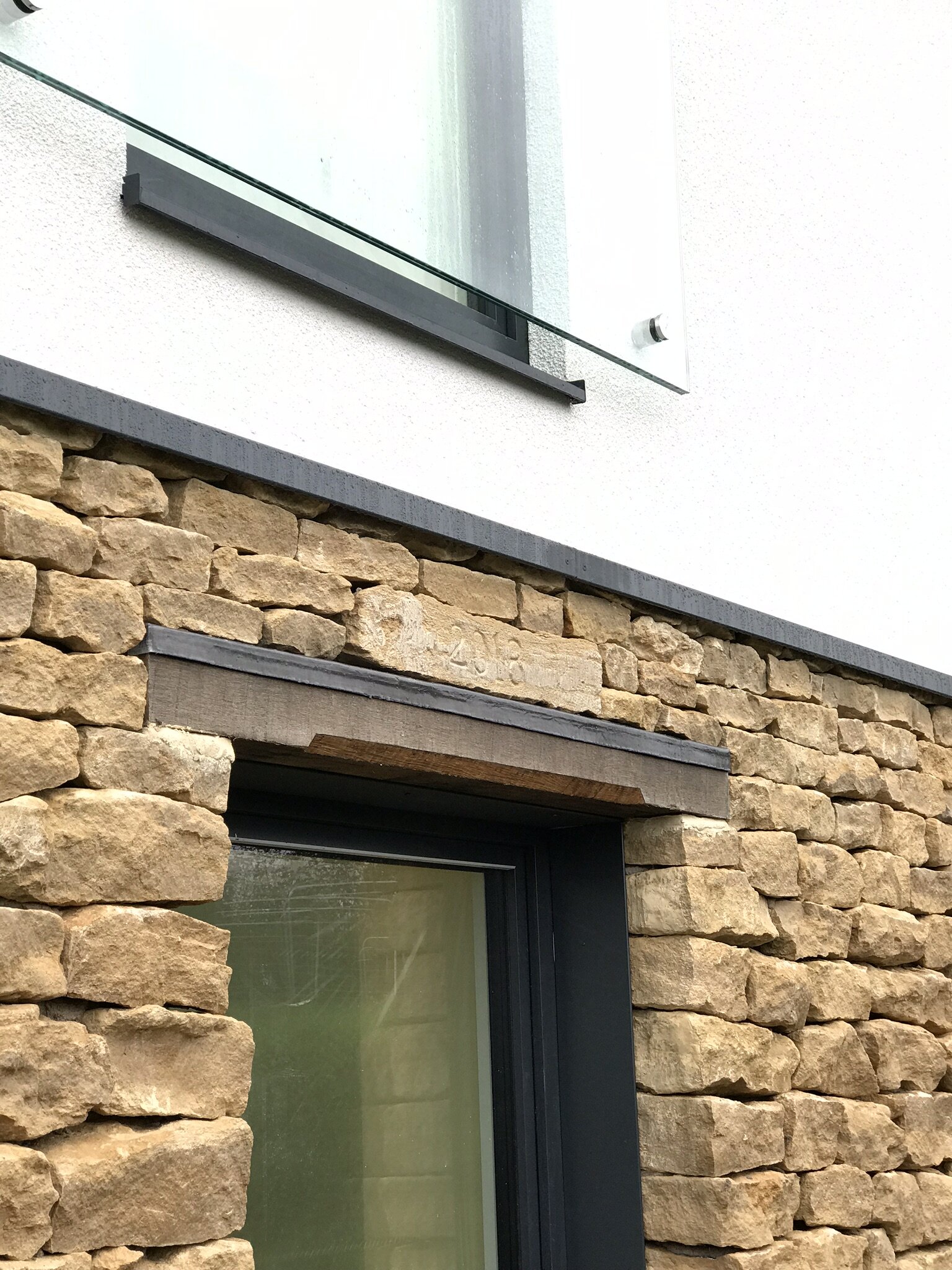  The combination of natural materials; rubble stone and oak lintels against crisp modern metal trims and smooth render makes the home seem very organic as if it has grown out of the ground. 