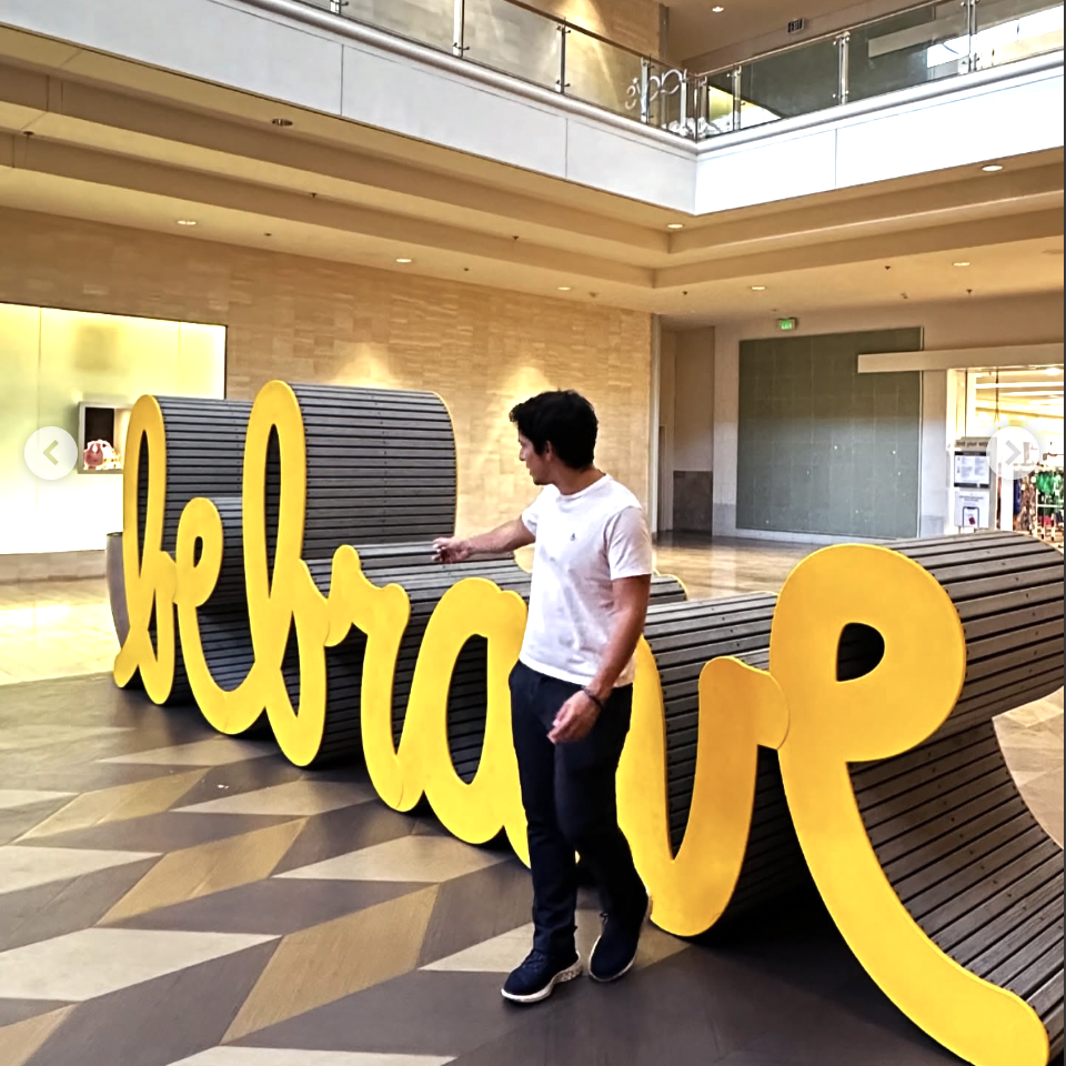 Visitor interacting with the Be Brave sculpture at Fashion Show Mall