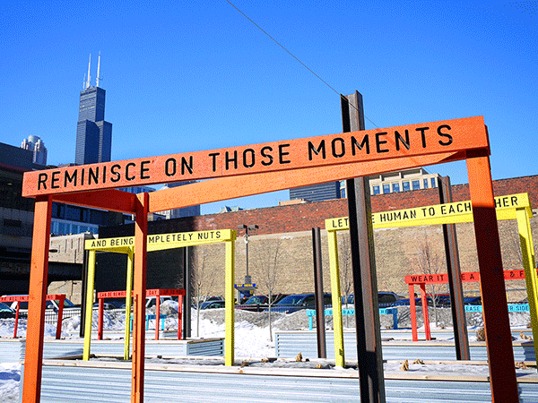 “Being Human Equals Hope” outdoor installation by Matthew Hoffman, yellow frame structure in snowy Chicago park with high-rise buildings.