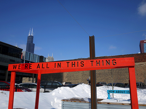 “Being Human Equals Hope” outdoor installation by Matthew Hoffman, yellow frame structure in snowy Chicago park with high-rise buildings.