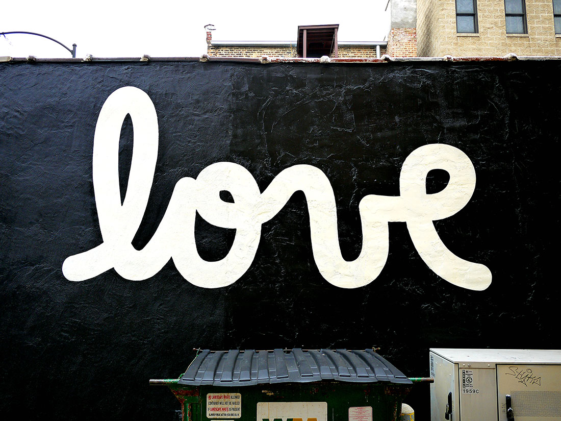 I painted the mural in my trademark cursive font in bold black and white. Loving one another is a bold choice, so I hoped to resonate the same impact. Countless selfies, weekend shots, wedding photographs, and the like have shown the response to the simple, bold, and loving message behind the mural.