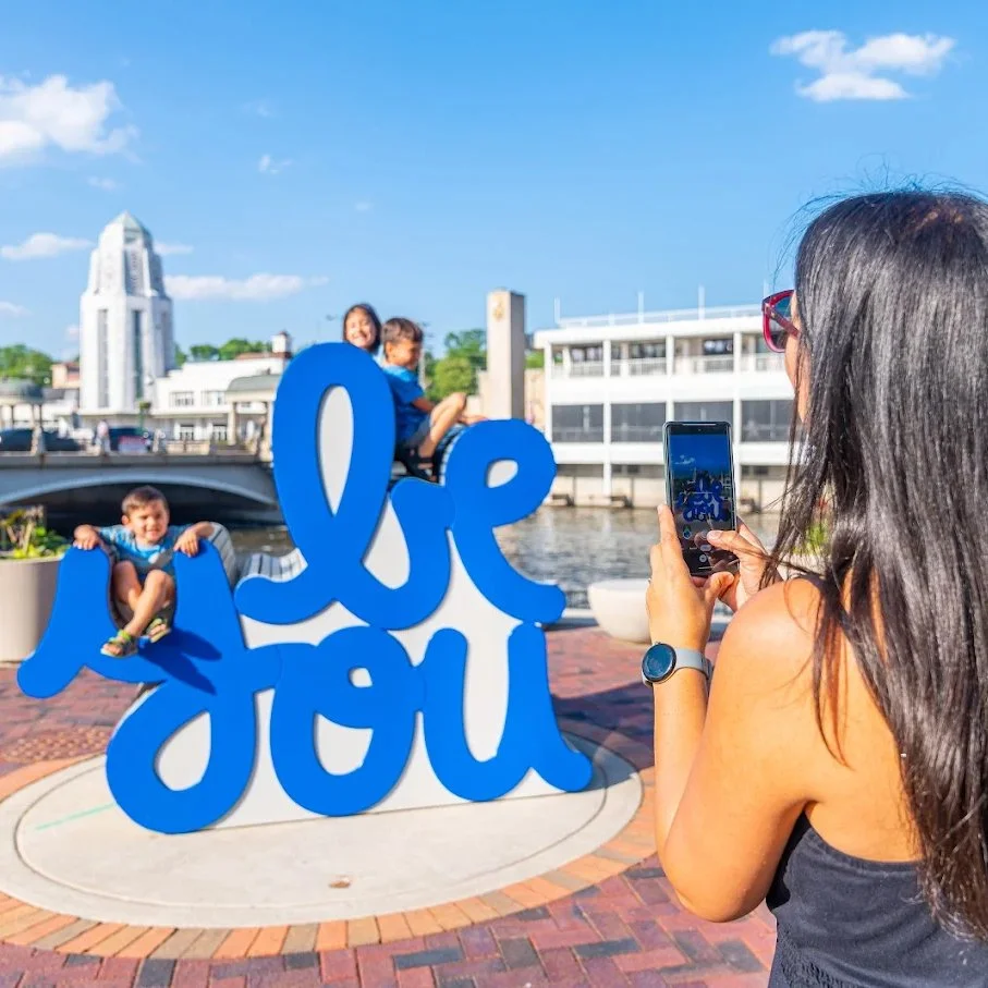 Close-up of the “Be You” letters designed by artist Matthew Hoffman, catching light along the Fox River, public art that encourages individuality.