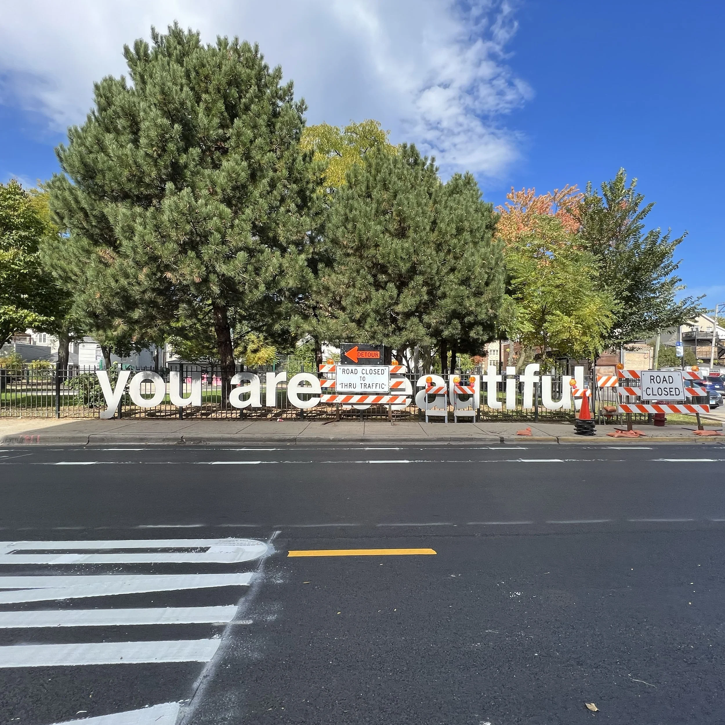 Construction interacting with Matthew Hoffman’s “Be You” sculpture, an uplifting example of placemaking and the power of public art.
