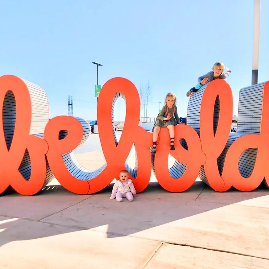 Community members interacting with Matthew Hoffman’s “Be bold” sculpture, an uplifting example of placemaking and the power of public art.