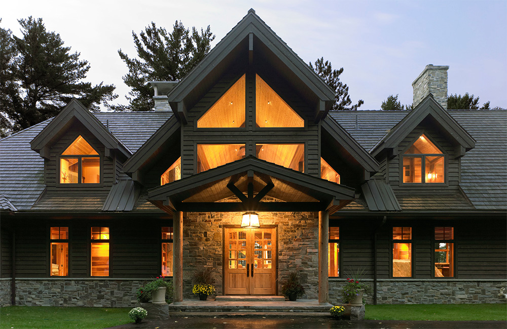 A deep covered entry portico provides shelter while the glow of the interior seen through lofty gable beckons and hints at the interior experience.