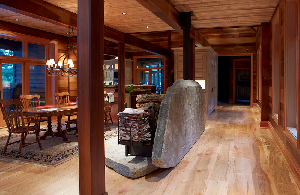 The dining room, adjacent to the kitchen, simply furnished, is “decorated "by the radiant Lindal post and beam structure and is separated from the main hallway by only this massive slab of indigenous stone….
