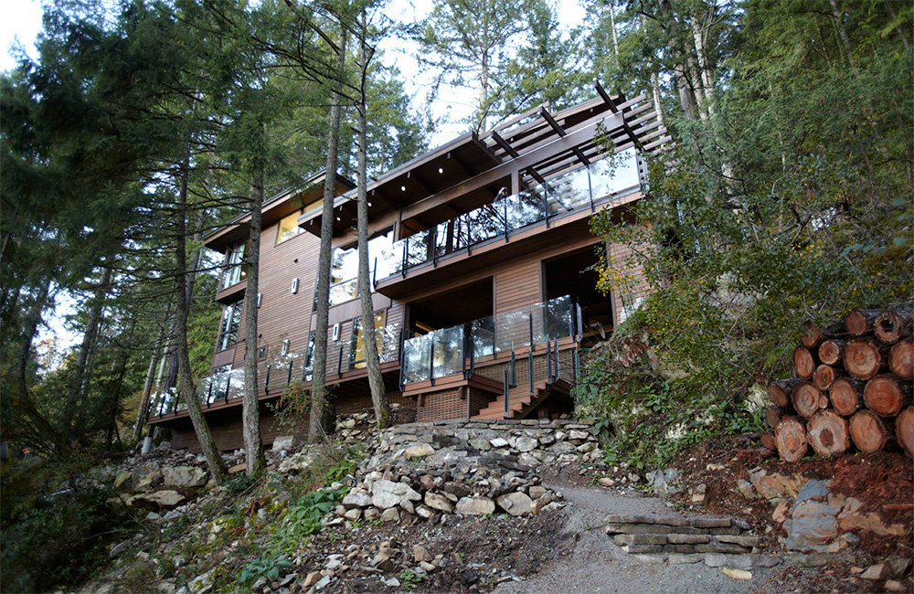   Once ashore, this cliffiside home is entered from the lowest of three levels. The siting and exterior hues make every effort to not compete with the natural environment in any way.     