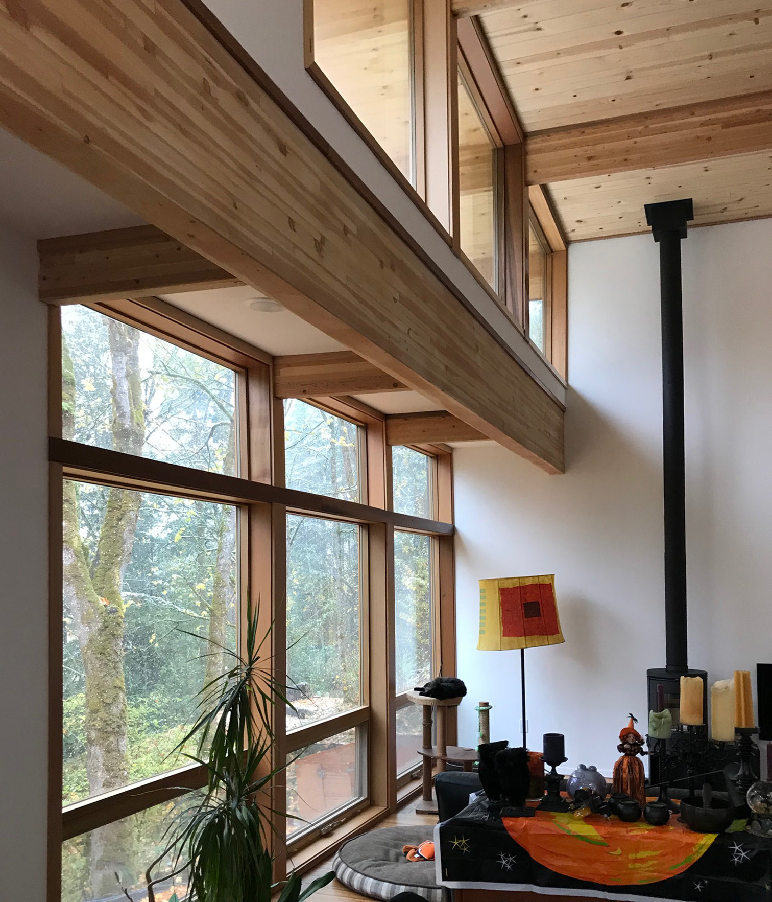 A flat roof over the last two feet of this area brings a high space into scale, provides alighting soffit, and brings natural daylight further into the room through the upper wall.