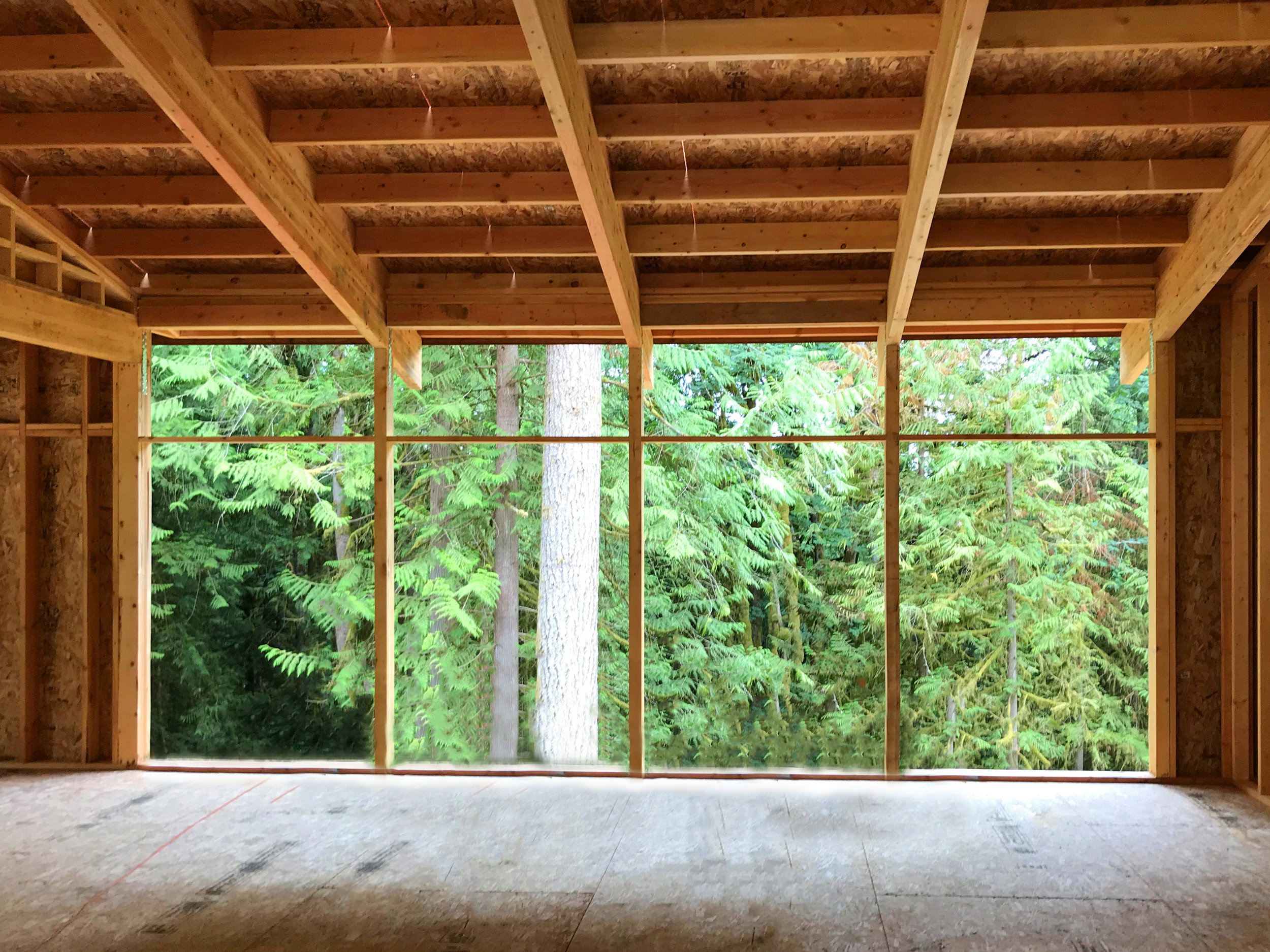 The roof beams are supported at the front, center, and rear of the house by laminated posts. The standard 5’4” spacing between the posts is all the support required. A 9’ 5” high by 22’ wide expansive glass view wall will be interrupted by only three 3 1/2” posts! Note how the laminated beams draw your eye through the window wall to the view beyond.