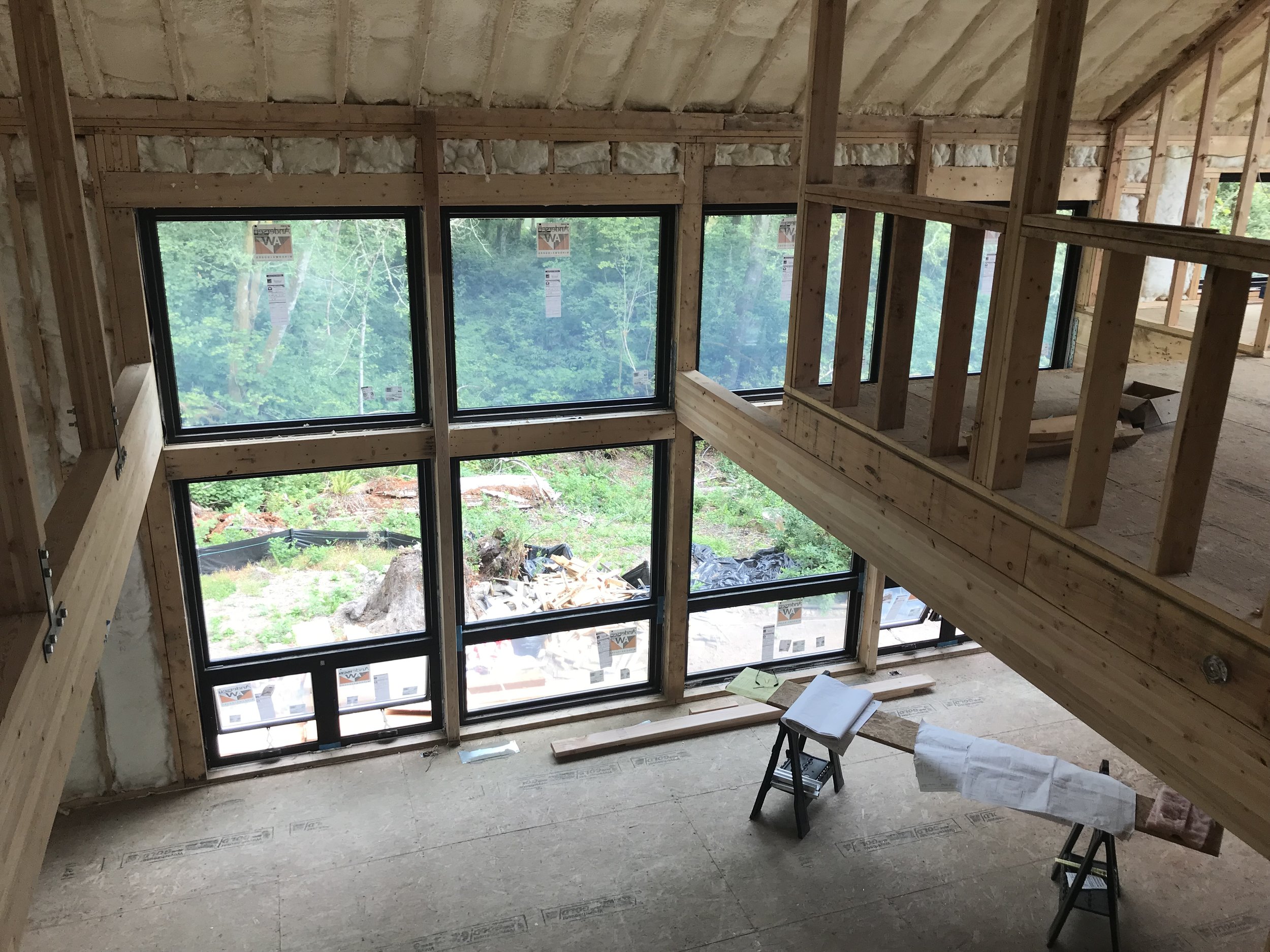 The view from the upper level office through the great room and to the view beyond