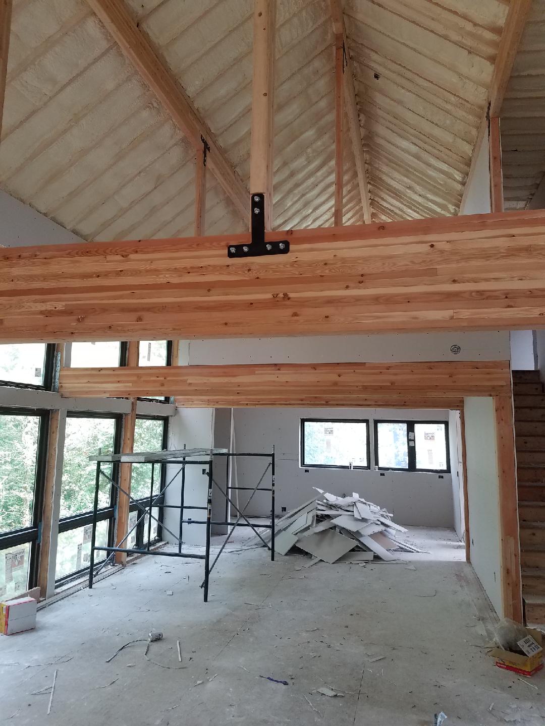 Now sheetrocked, the great room takes shape. Laminated girders and roof beams to the fore!