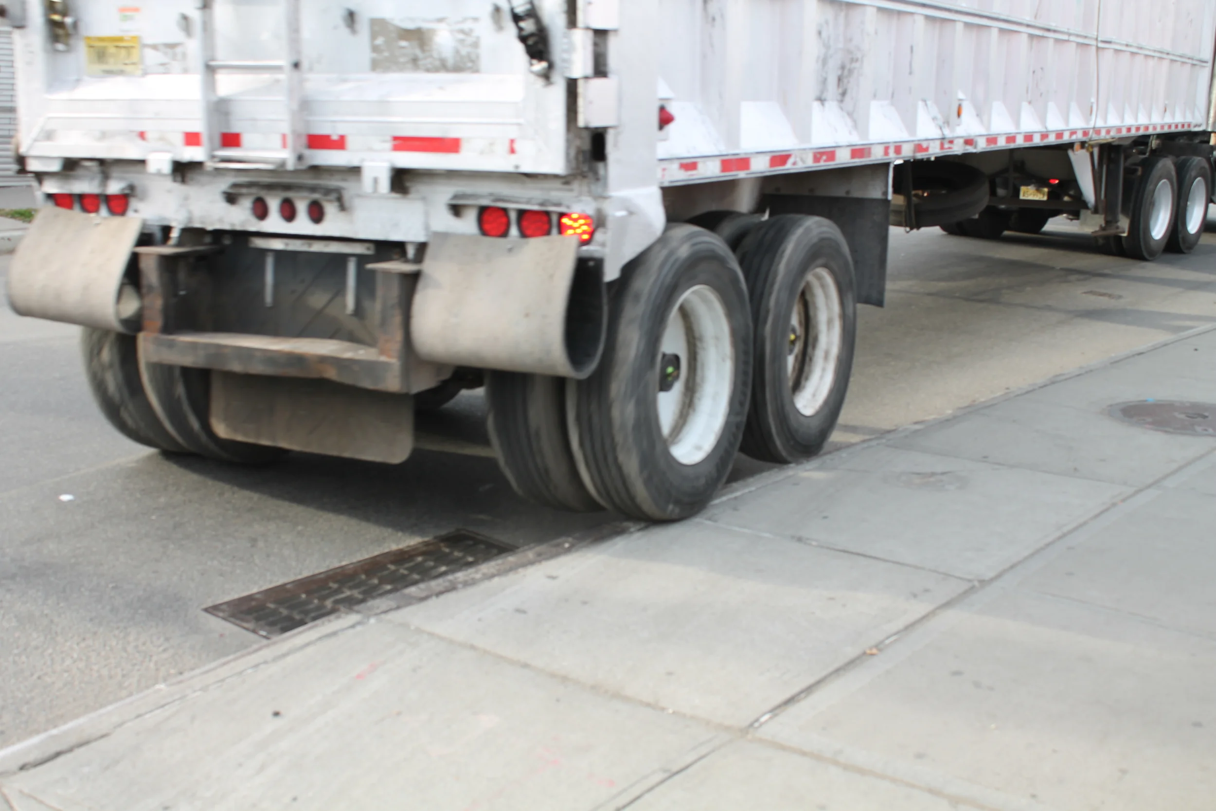 The only way an 18-wheel tractor trailer was able to make a wide turn from Liberty Avenue onto 170th Street was by jumping its rear wheels onto the sidewalk, coming within a few feet of a reporter, who was almost too startled to be able to take this photograph in time. Source : Louis Flores