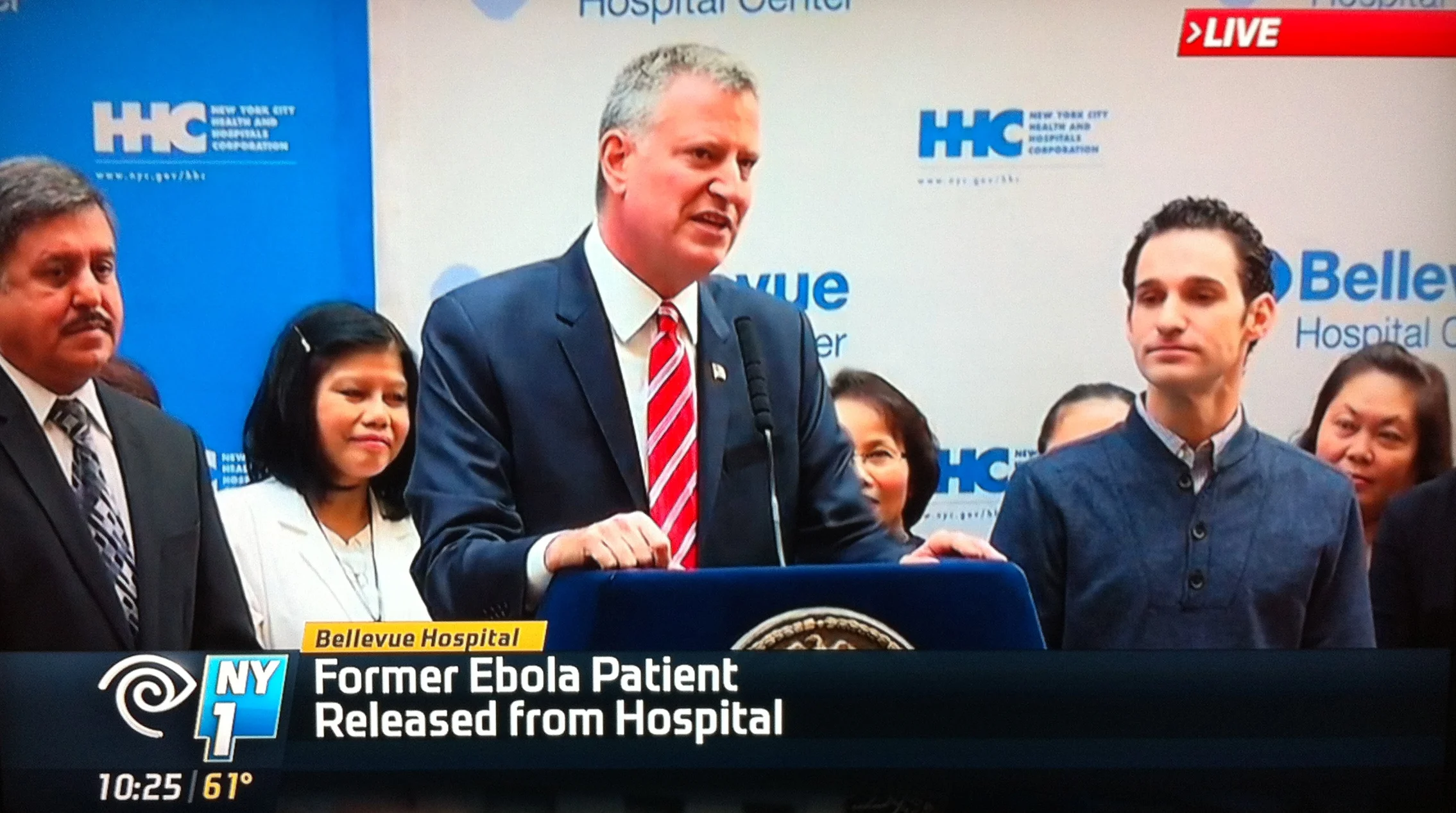 New York City Mayor Bill de Blasio speaking on the occasion of the hospital discharge of Dr. Daniel Spencer, right, the first person to be treated for Ebola in New York City. Source : NY1 Screen Shot