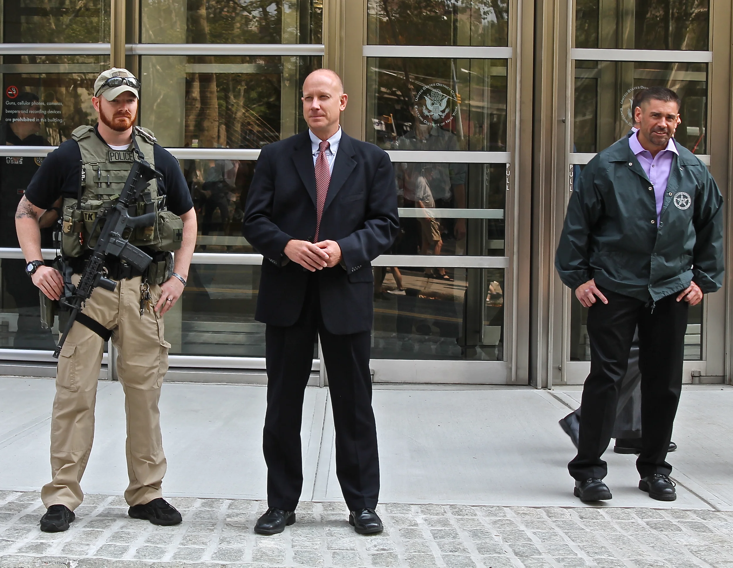As LGBT, public health, and social work activists peacefully demonstrated on Cadman Plaza Park and on Cadman Plaza Park East, F ederal marshals stood guard with automatic rifles with high capacity magazines outside the U.S. District Courthouse in Brooklyn in a display of excessive force that some activists say they found obnoxious. Source : Louis Flores/Progress Queens