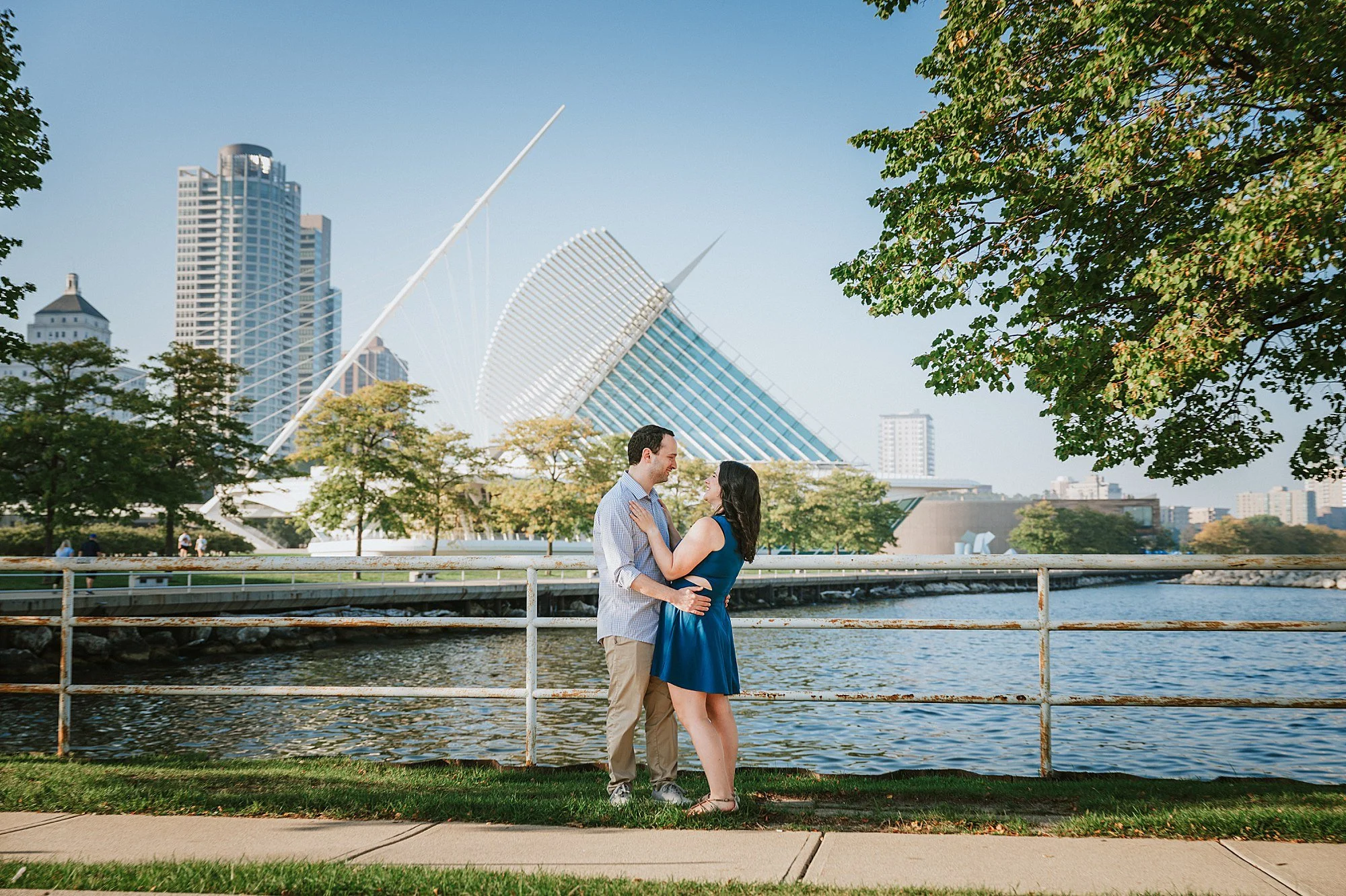 Happy Couple who are getting Married in Milwaukee pose by the Art Museum for their engagement Session