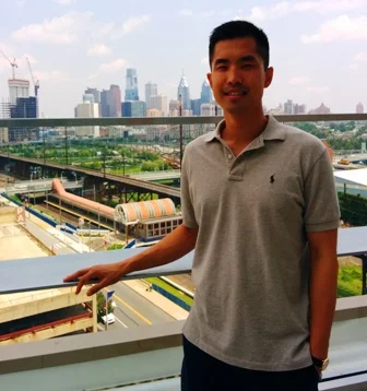 Jason on the Henry A. Jordan M’62 Medical Education Center rooftop balcony with a view of Penn Park and the Center City Skyline.