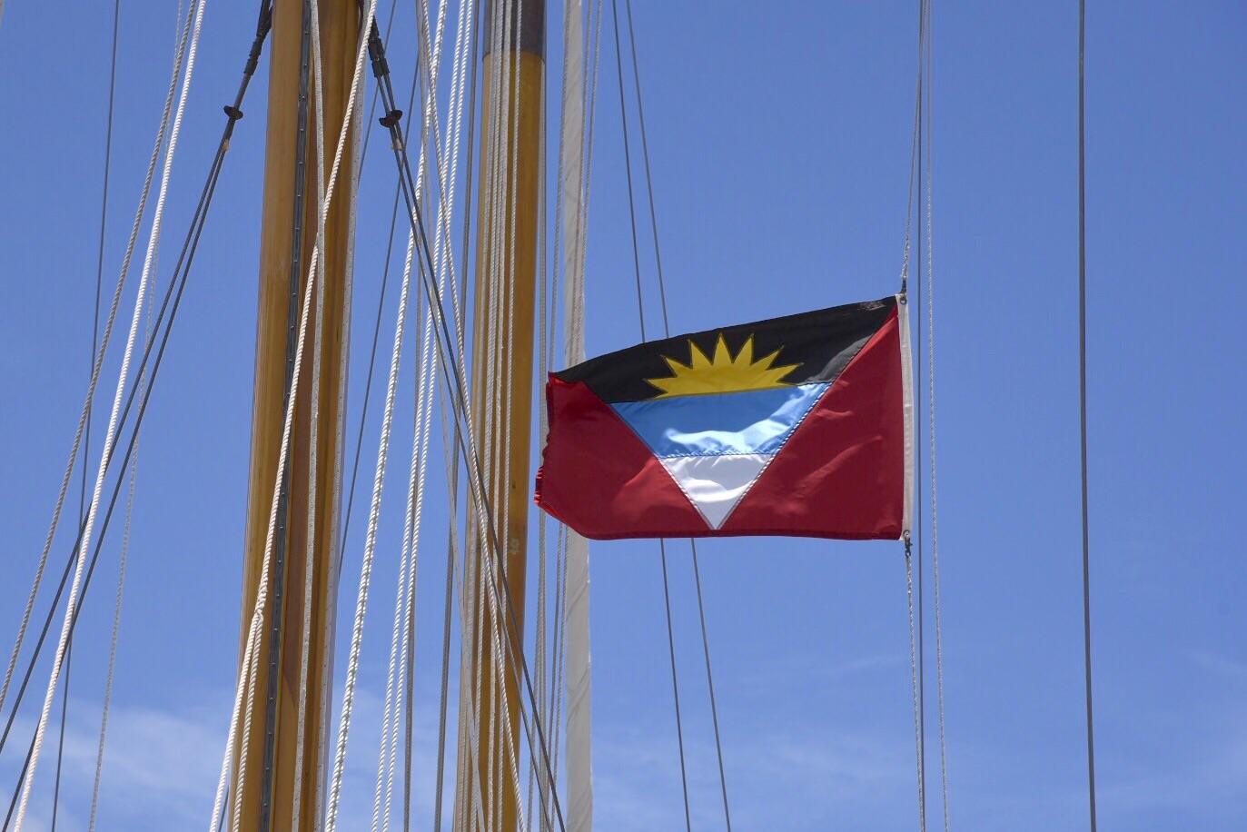 The Antigan glad flies above a docked yacht