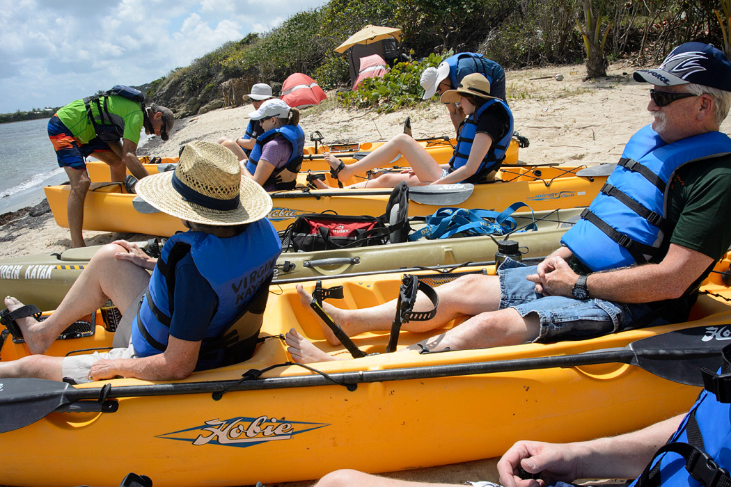 Kayaks are launched in the Salt River Bay National Park, where there are apparently permanent camp sites in the background.