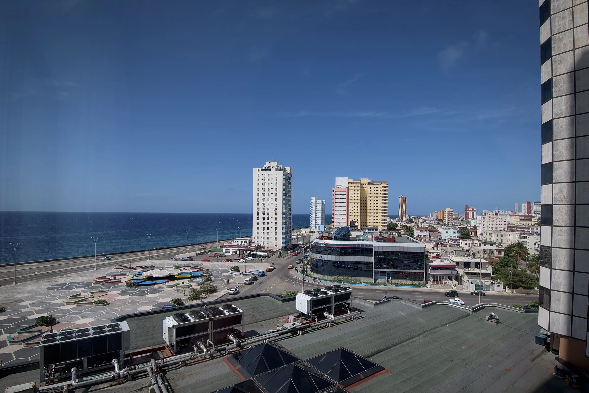 A view to the Malecon, with its major ring road around the city, with no traffic and virtually empty parking lots at 5 PM on a weekday. 