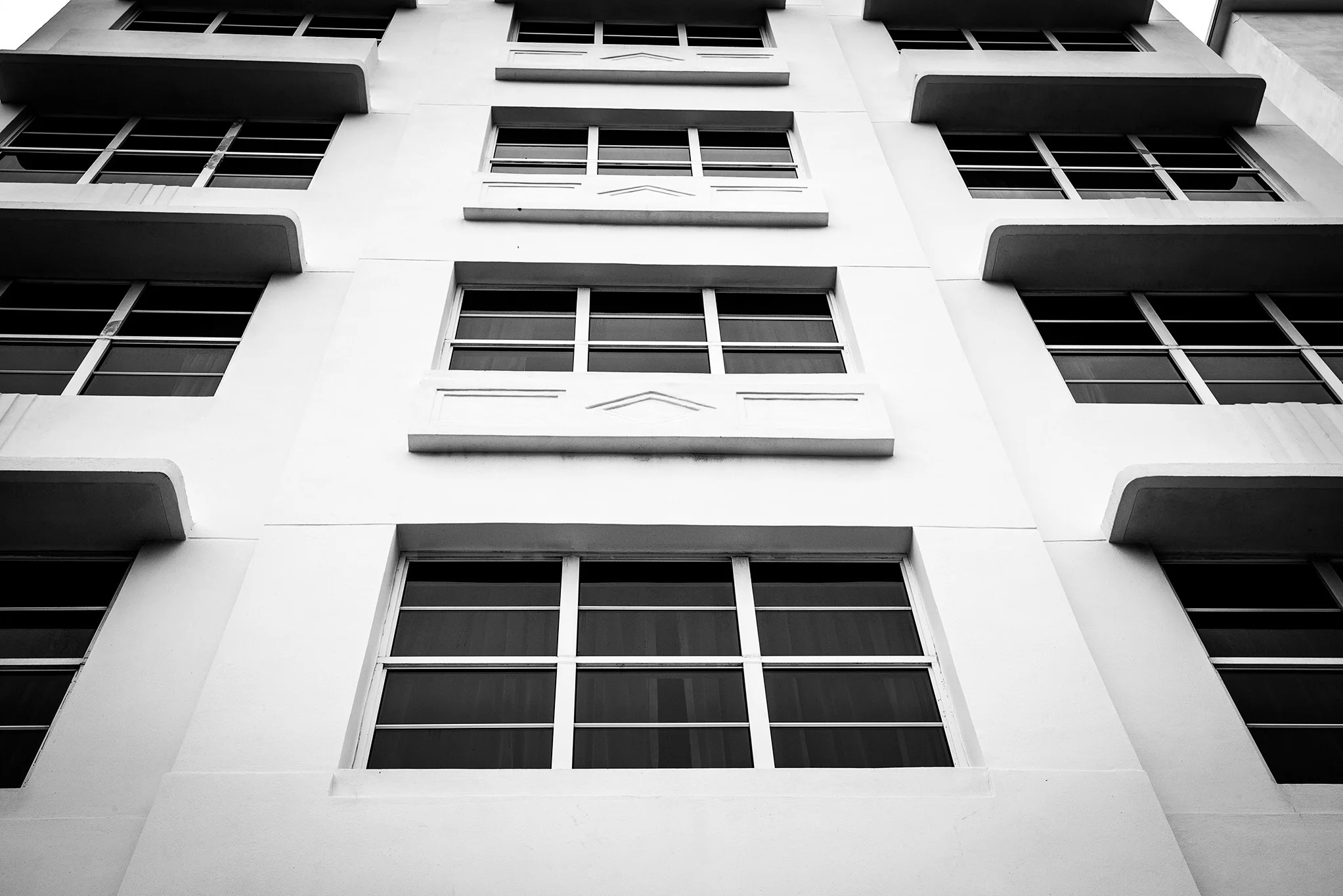 A building stripped of its color draws your attention to the curved "eyebrows" over the windows. 