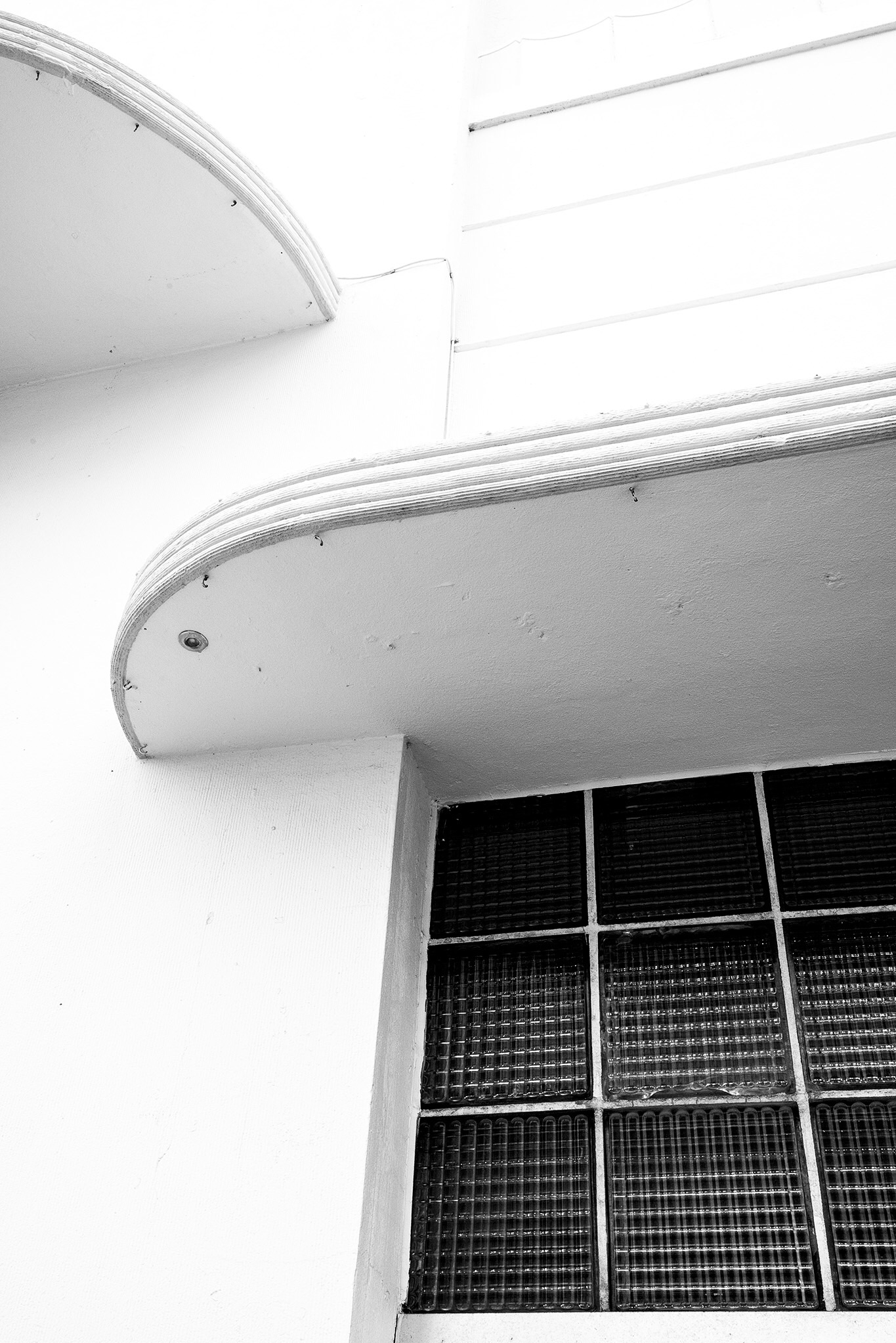 A detail of glass block and eyebrows over the windows with streamlines on them. 