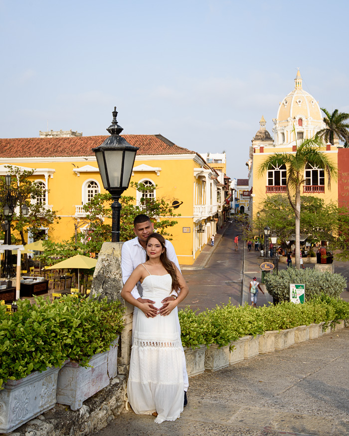 A young couple poses for photos in a scenic plaza