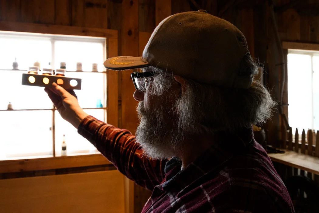 Doug shows visitors the the various colors of different Grade A maple syrup. 