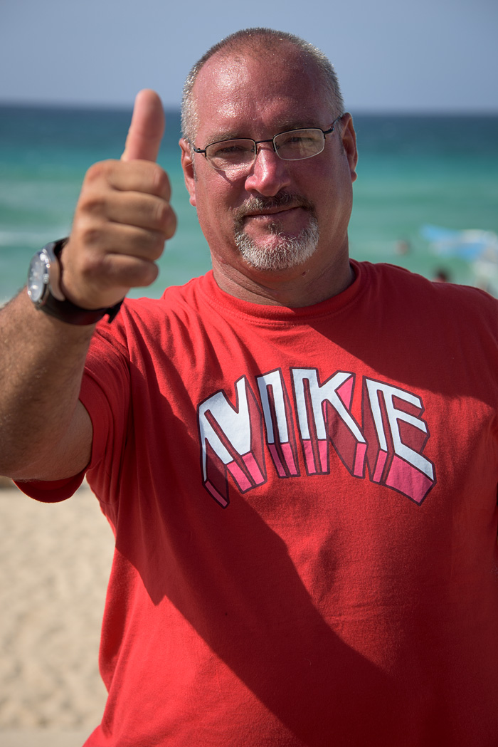 A man on the beach expresses his enthusiasm for Americans with his shirt and his gestures!