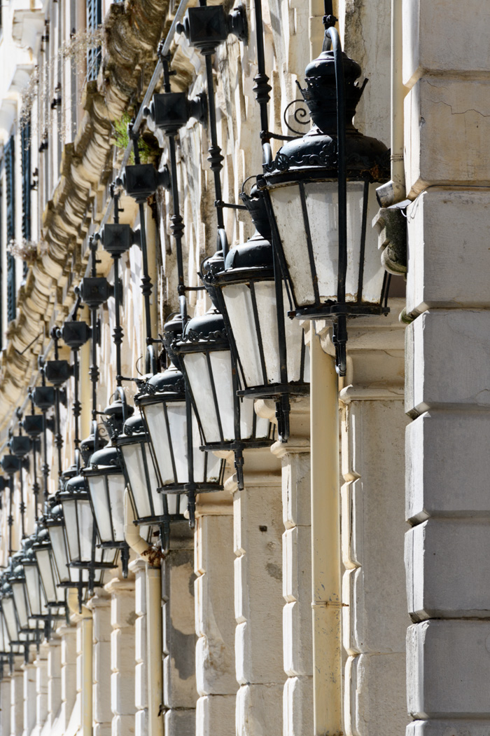 The Colonnade along the Spianada, below shops, flags and street signs in Corfu Town.