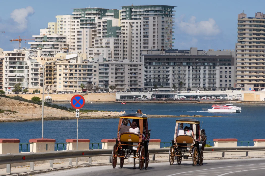 New buildings and old horse carts demonstrate the mix of old and new in Valletta.