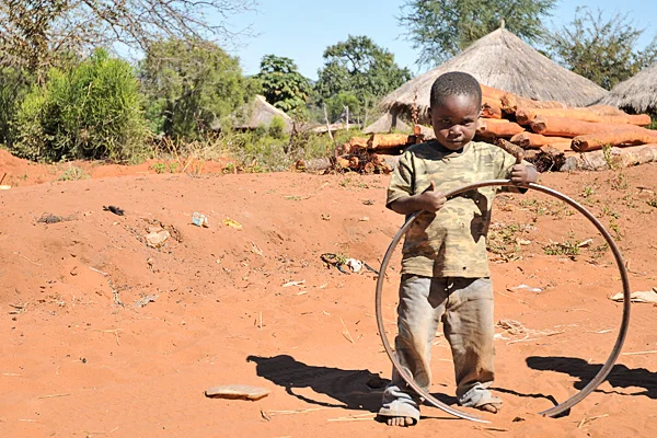 A small boy gives visitors the thumbs up in Zambia