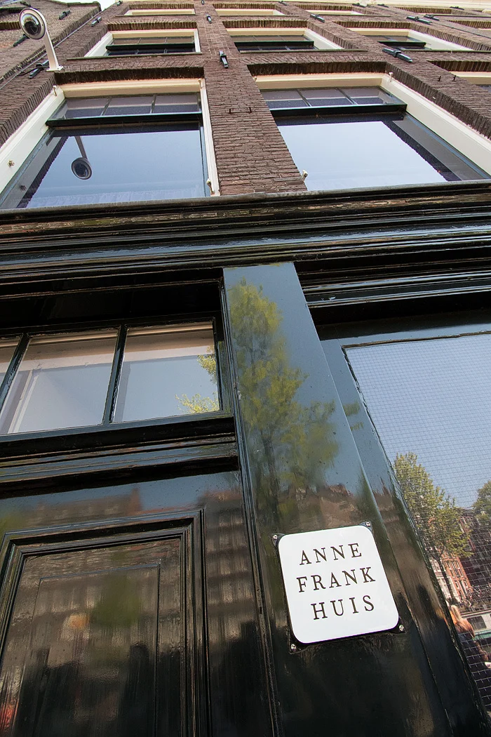The Prinsengracht canal is reflected on the building that housed Anne Frank and her family during Nazi occupation. 