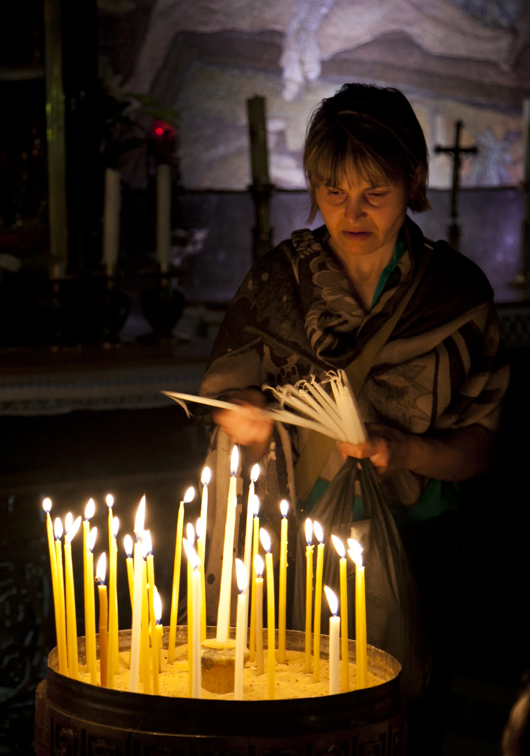 A pilgrim lights candles in the Church of the Holy Sepulchre, built over the site where many believe Jesus was crucified and buried. The church encompasses the last several stations of the Via Dolorosa, the journey of Jesus from the place of his sentencing to his tomb, and is a supremely important pilgrimage destination for Christians world-wide. (31 July 2013)
