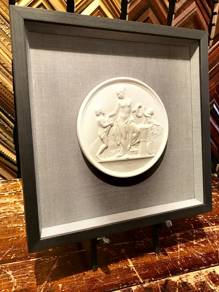 Small relief sculpture floated on gray linen and shadowboxed in charcoal.