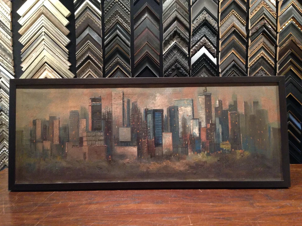 Mid-Century skyline painting framed in dark wood.