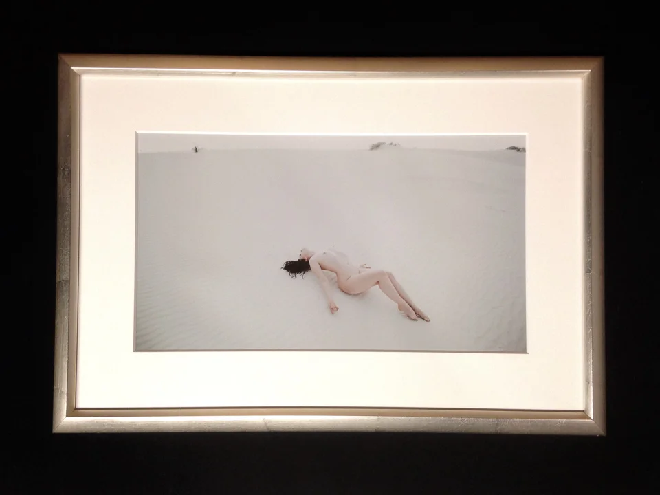 White sands photograph framed in curvy-smooth silver frame.