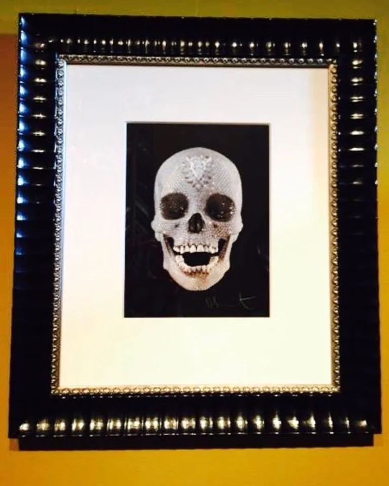 Bejeweled Damien Hirst print framed in patterned black with beaded silver fillet.