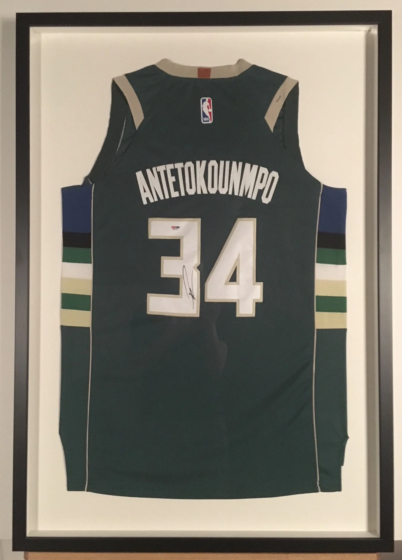 Autographed Milwaukee Buck’s Antetokounmpo Jersey stitch mounted and shadowboxed in charcoal on maple.
