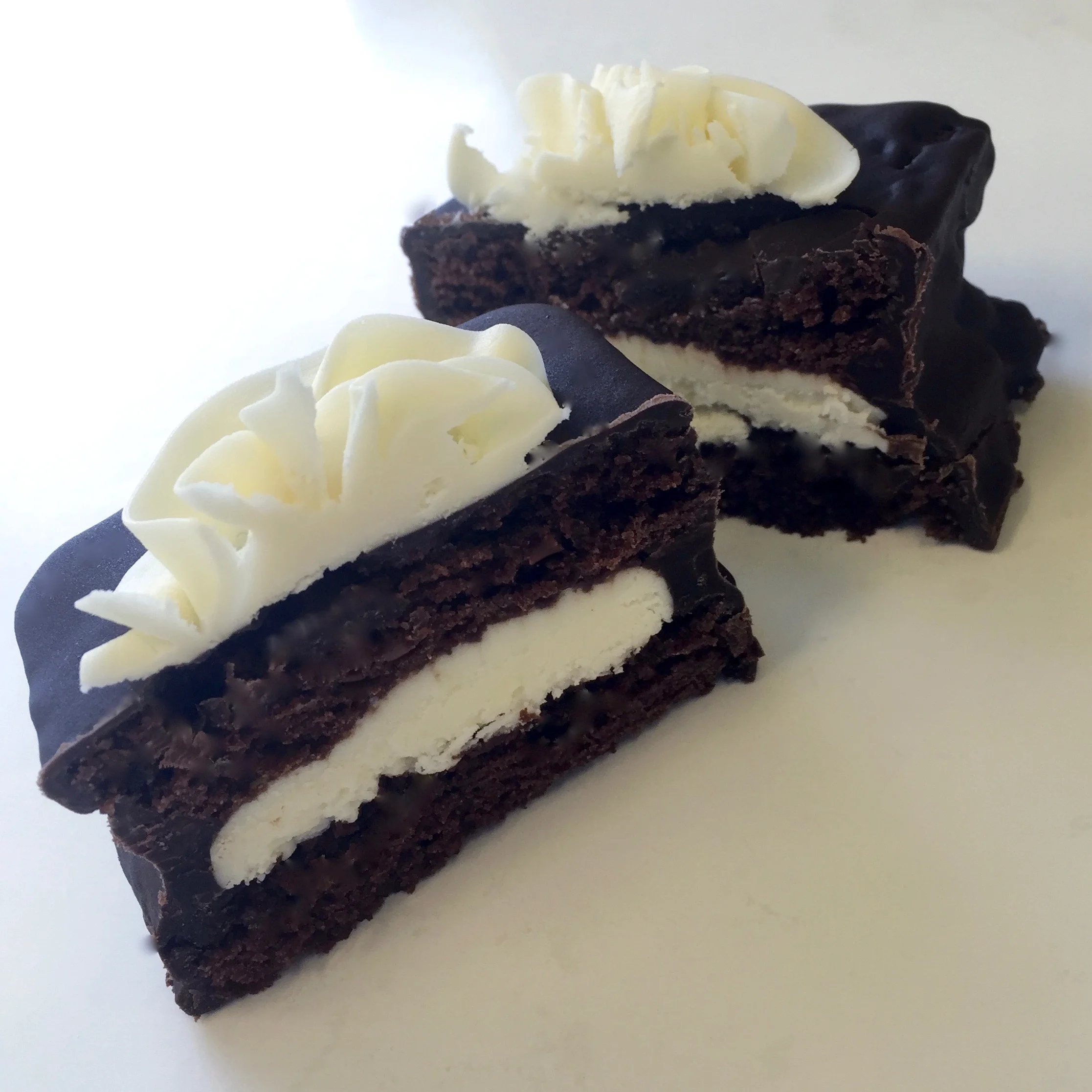 Cake Bars Two layers of cake filled with a variety of buttercream flavors and finished with a dark or white chocolate glaze. 