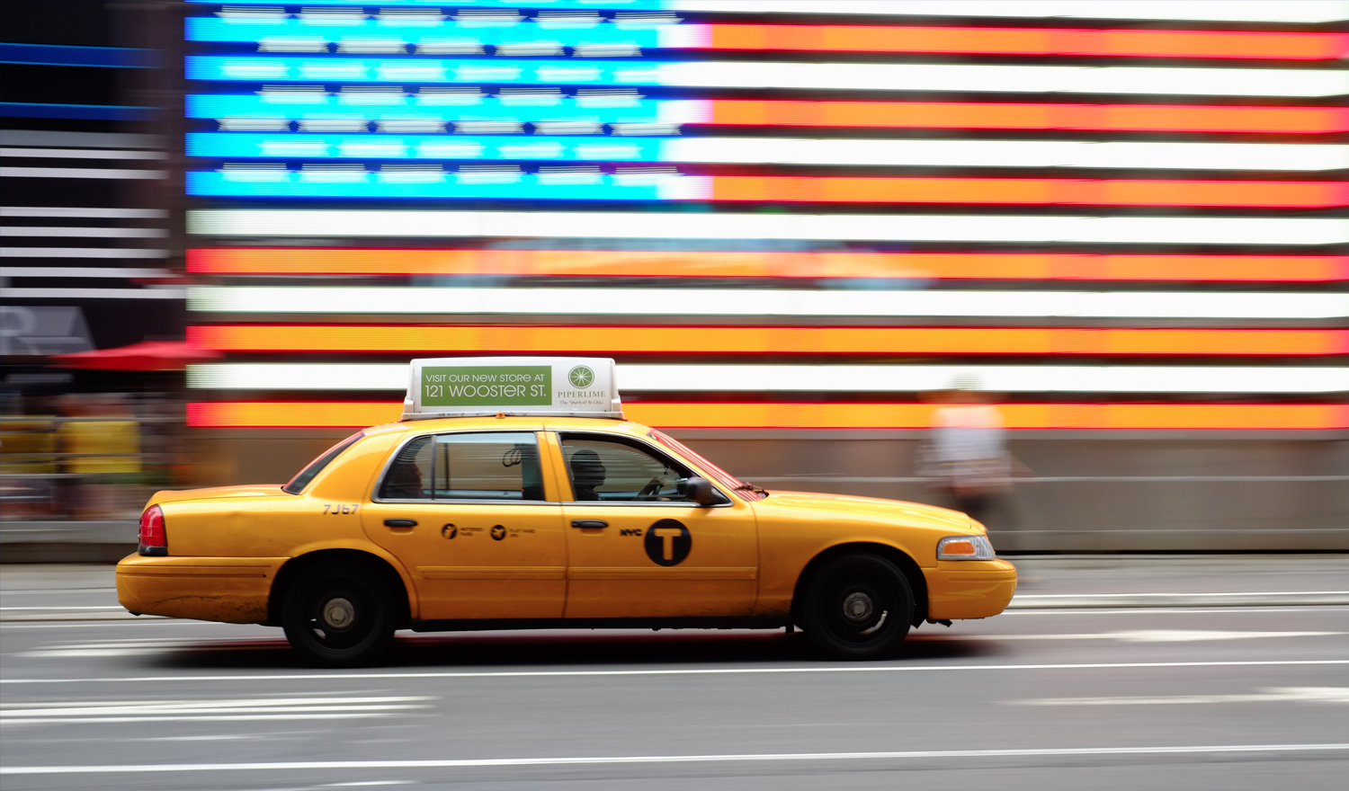 Taxi by neon sign of American flag