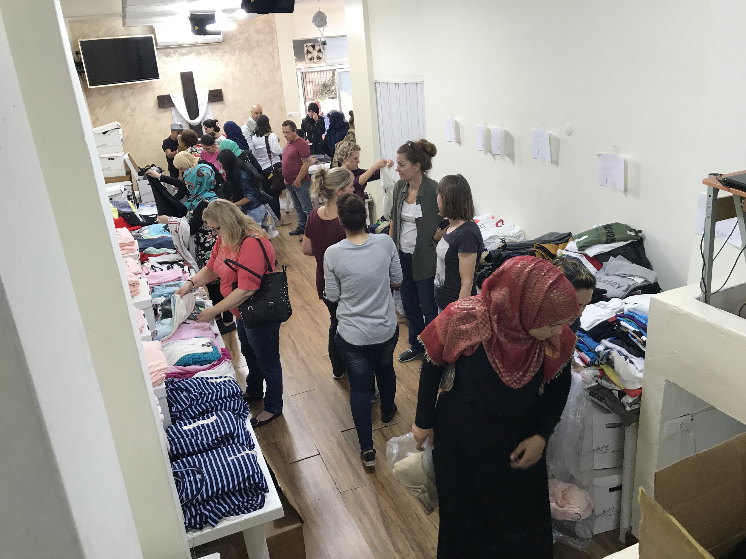 Refugee women "shop" for clothes for their families