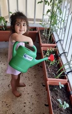 Ag little girl watering smiling.jpg