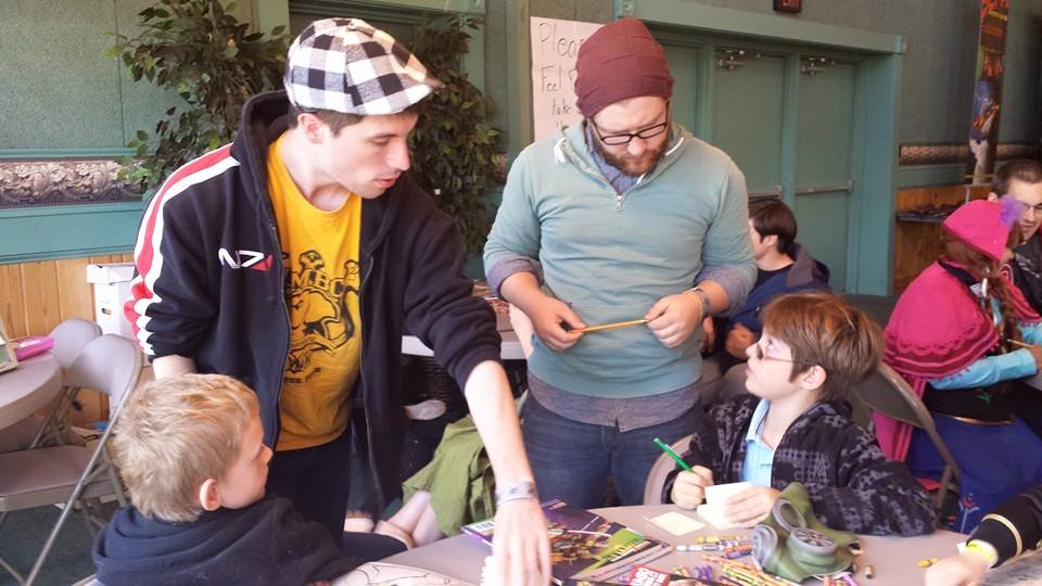 Jimmy Horner (standing, left) and Jake Heagy (standing, right) instruct children on how to create their own moving cartoon during Southern Maryland Comic-con .